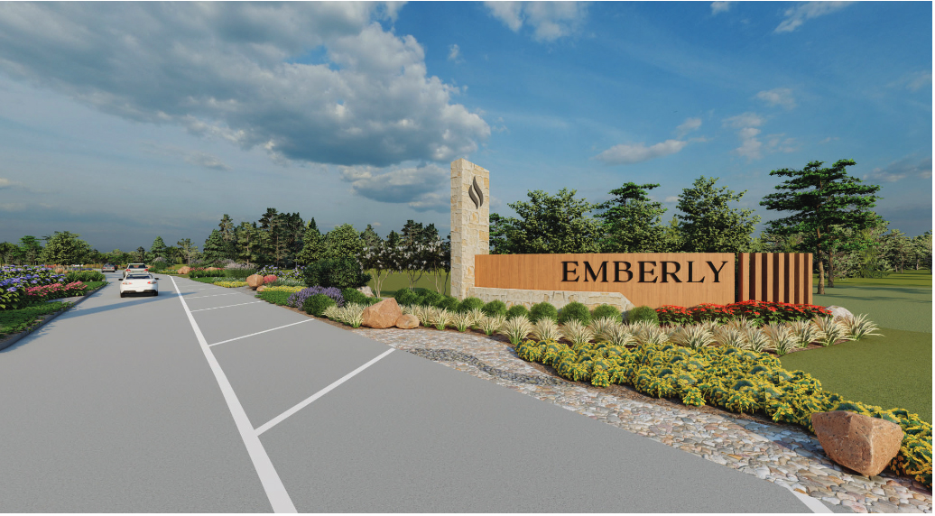 Entrance sign reading "EMBERLY" near Rosenberg beside a landscaped area with shrubs and rocks, with a road and vehicles on the left in this beautiful master planned community.