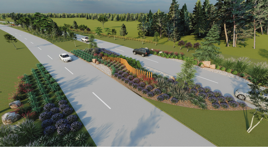 Aerial view of a landscaped roundabout near Richmond, featuring roads lined with greenery, bushes, and a decorative wooden fence, with cars driving on the adjacent roads. New homes in Fort Bend County are visible in the background alongside the forested area.