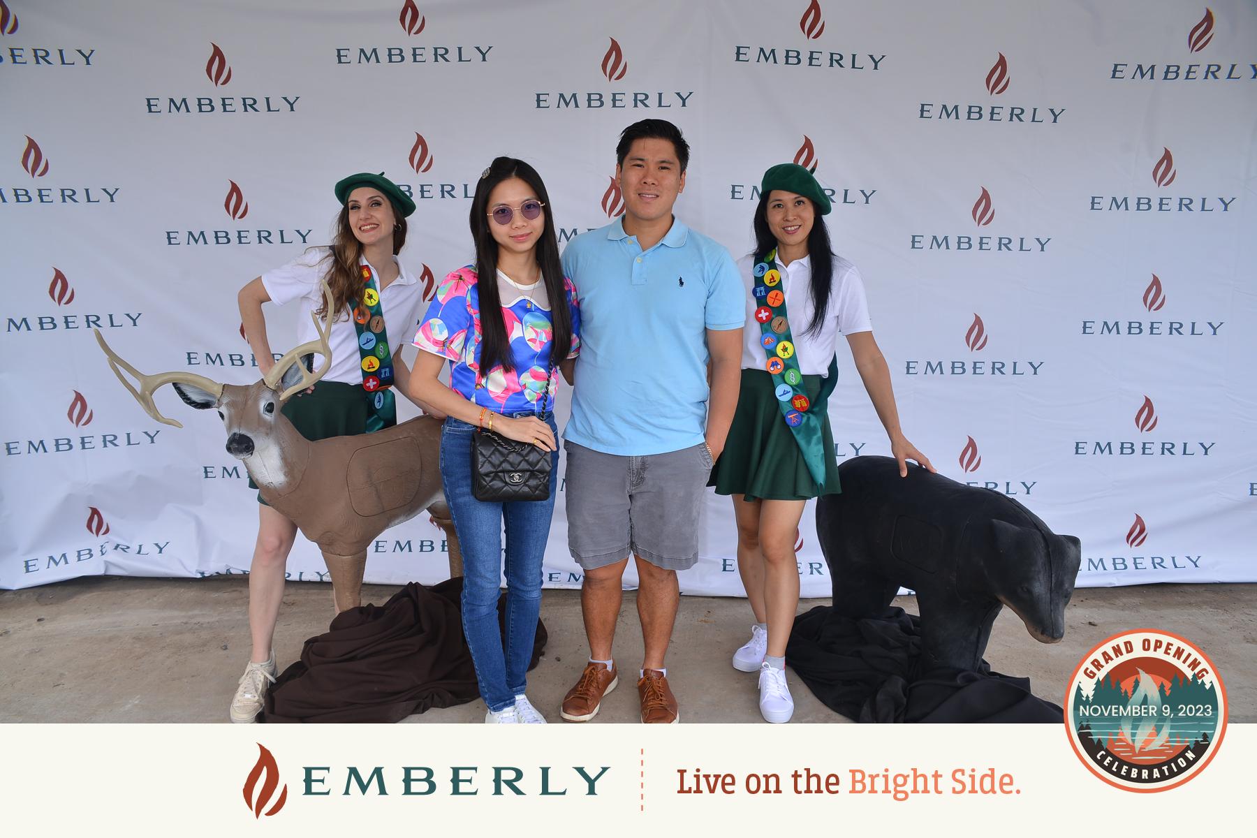 Two people stand in the center, flanked by two women dressed as Girl Scouts posing with animal props. The backdrop displays the "EMBERLY" logo and a "Grand Opening" seal dated November 9, 2023. This event marks another exciting milestone for this master planned community near Richmond in Fort Bend County.