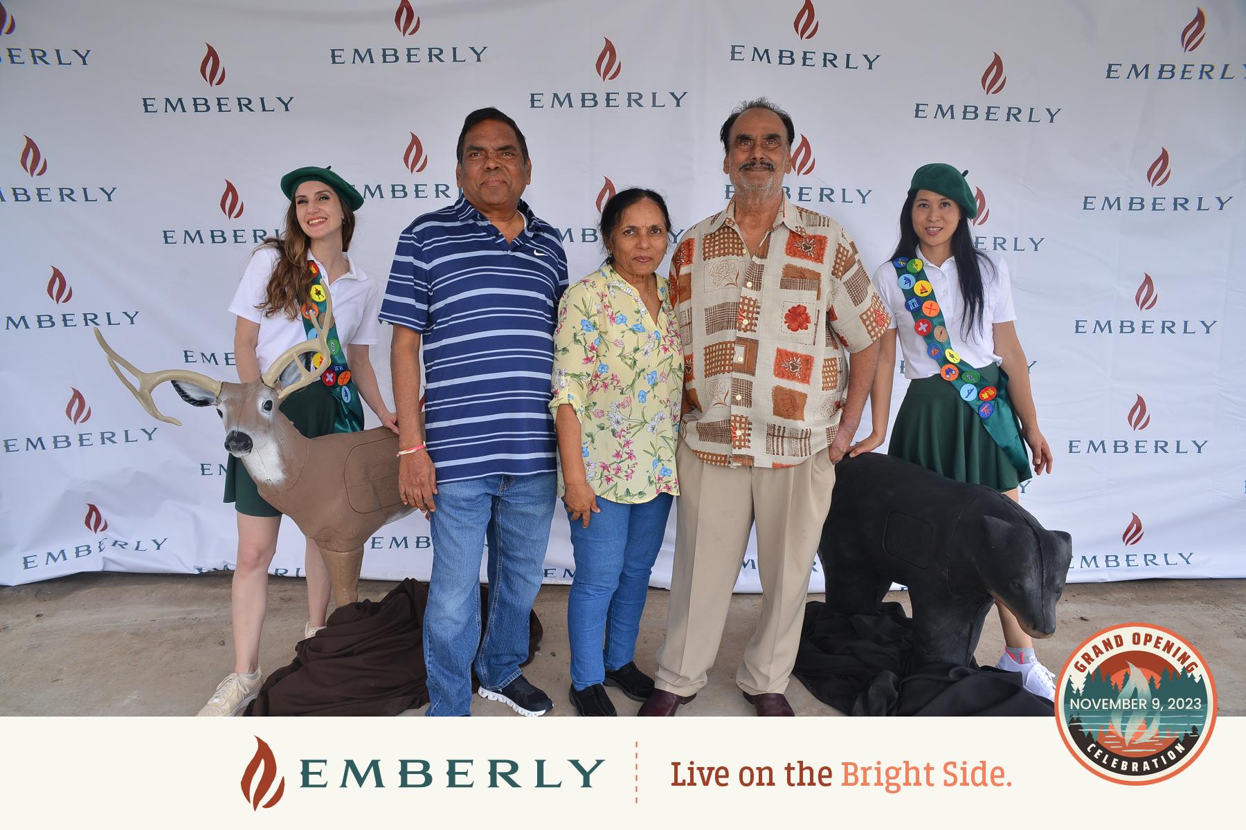 Three adults stand between two deer cutouts, with two Girl Scouts on either side, in front of an Emberly branded backdrop. Text on the image mentions "Grand Opening, November 9, 2023." Join us in celebrating new homes near Richmond in Fort Bend County.