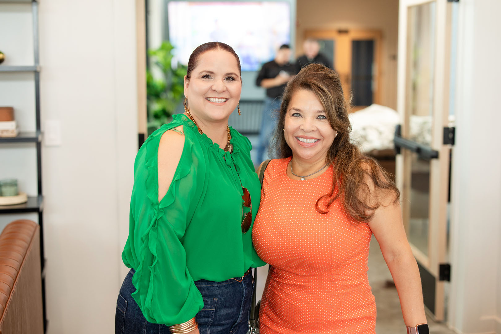 Two women smiling and standing indoors at Amenity Village