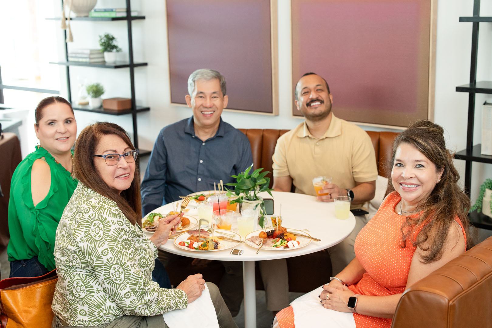 Five adults sit around a round table at Haven Amenity Village